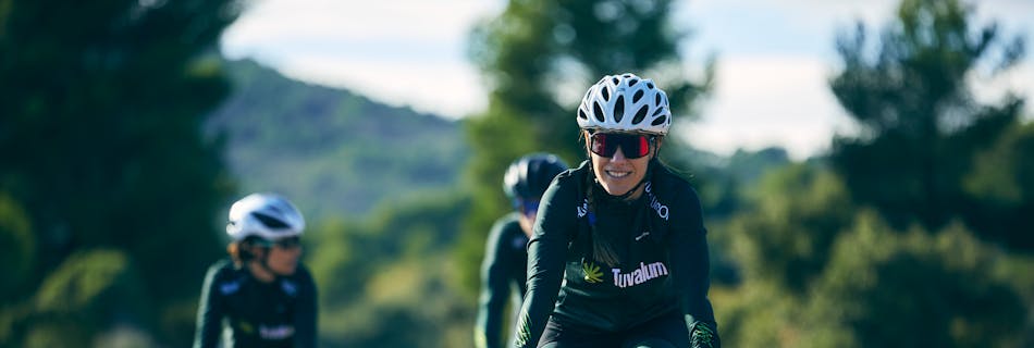 A group of women cyclists enjoys a sunny outdoor ride on scenic roads. Perfect for sports and lifestyle themes.