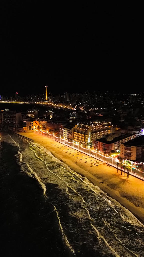 Captivating aerial view of Benidorm's illuminated beachfront and cityscape at night.